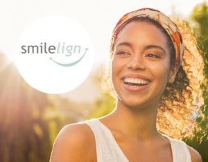 Woman smiling with straight teeth and Smilelign logo