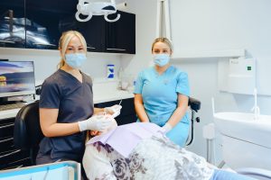 Image of the practice manager with dental nurse working on a patient in clinic