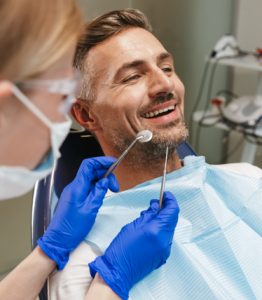Man smiling with mouth open about to get treated by dentist