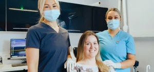 Jenny and dental nurse with a patient smiling at camera